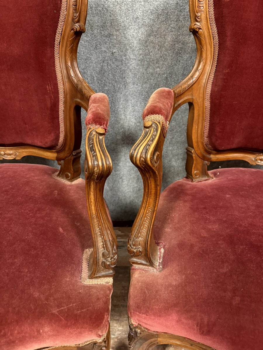 Paire de fauteuils cabriolets de style louis XV Rocaille en noyer vers 1850.  Jolie tapisserie façon velours de Gênes  Ossature abondement sculptée.   Pieds cambrés.  H98 X 65 X 54